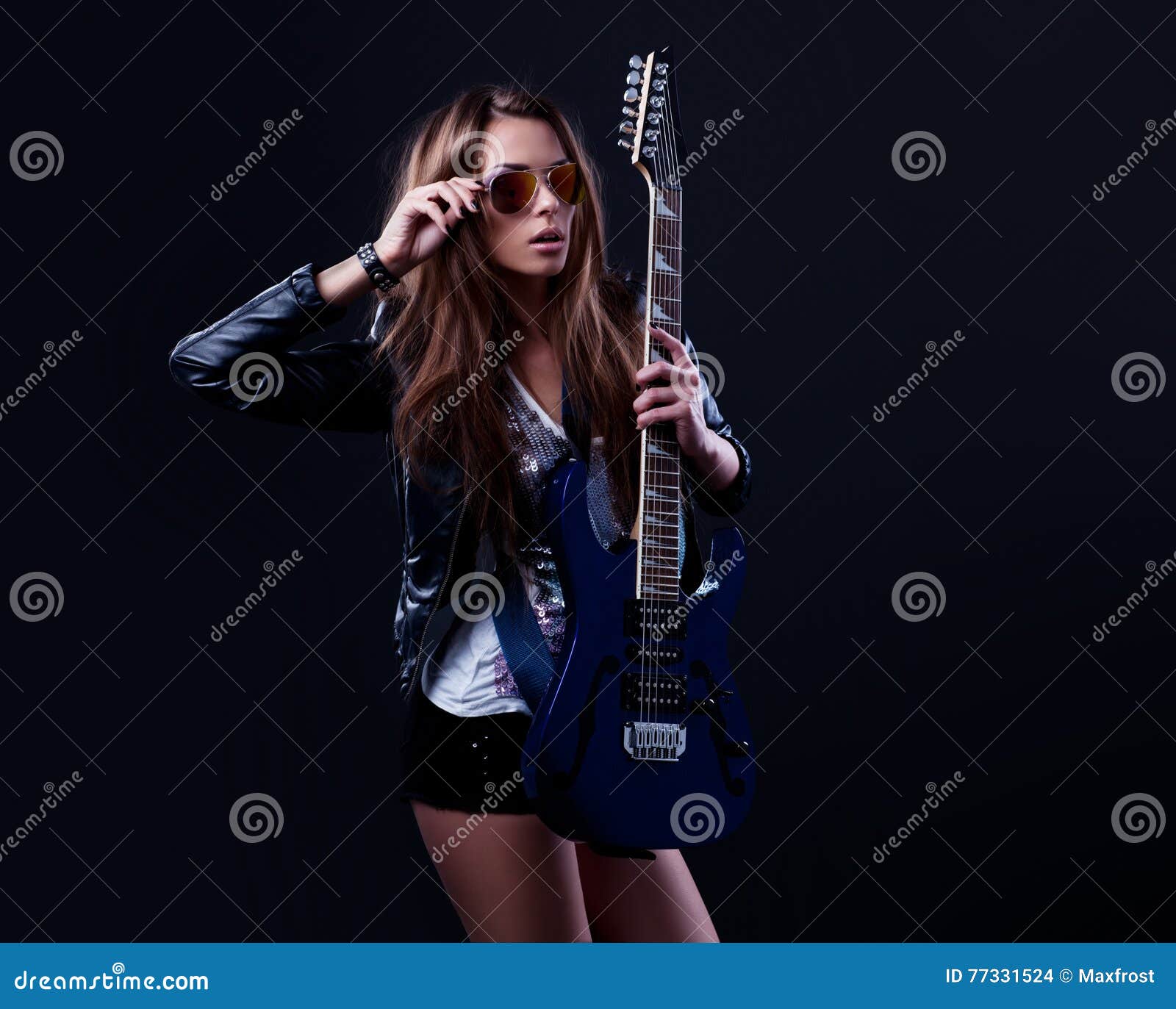 young rockstar woman with blue electric guitar
