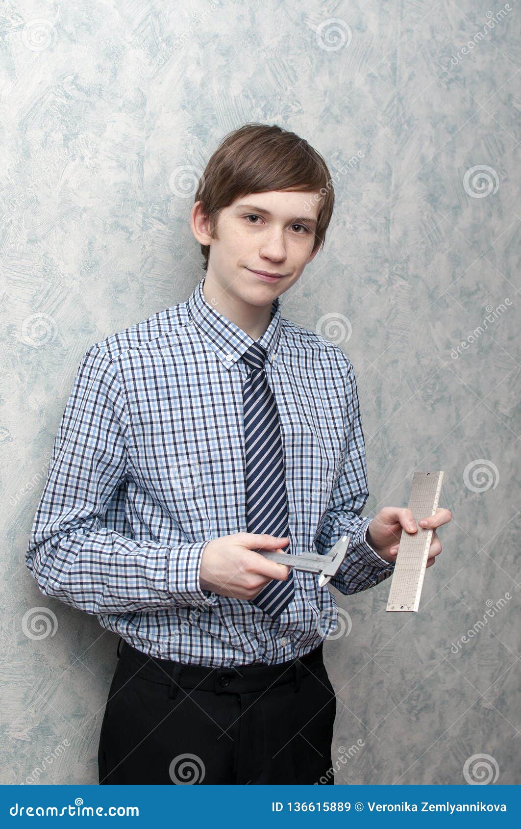 The Young Russian Guy Holds a Caliper and a Metal Ruler in Hand Stock