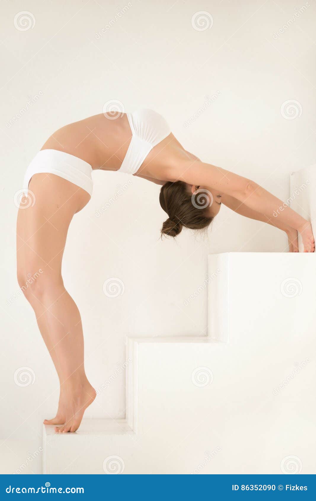 young attractive woman standing backward bend, white color