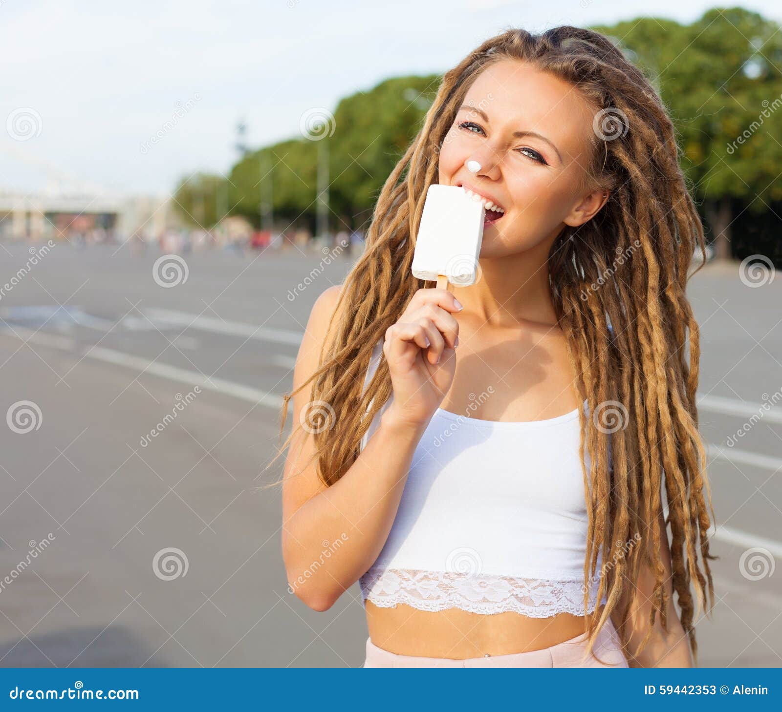 Young Blonde Girl With Dreads Eating White Ice Cream In