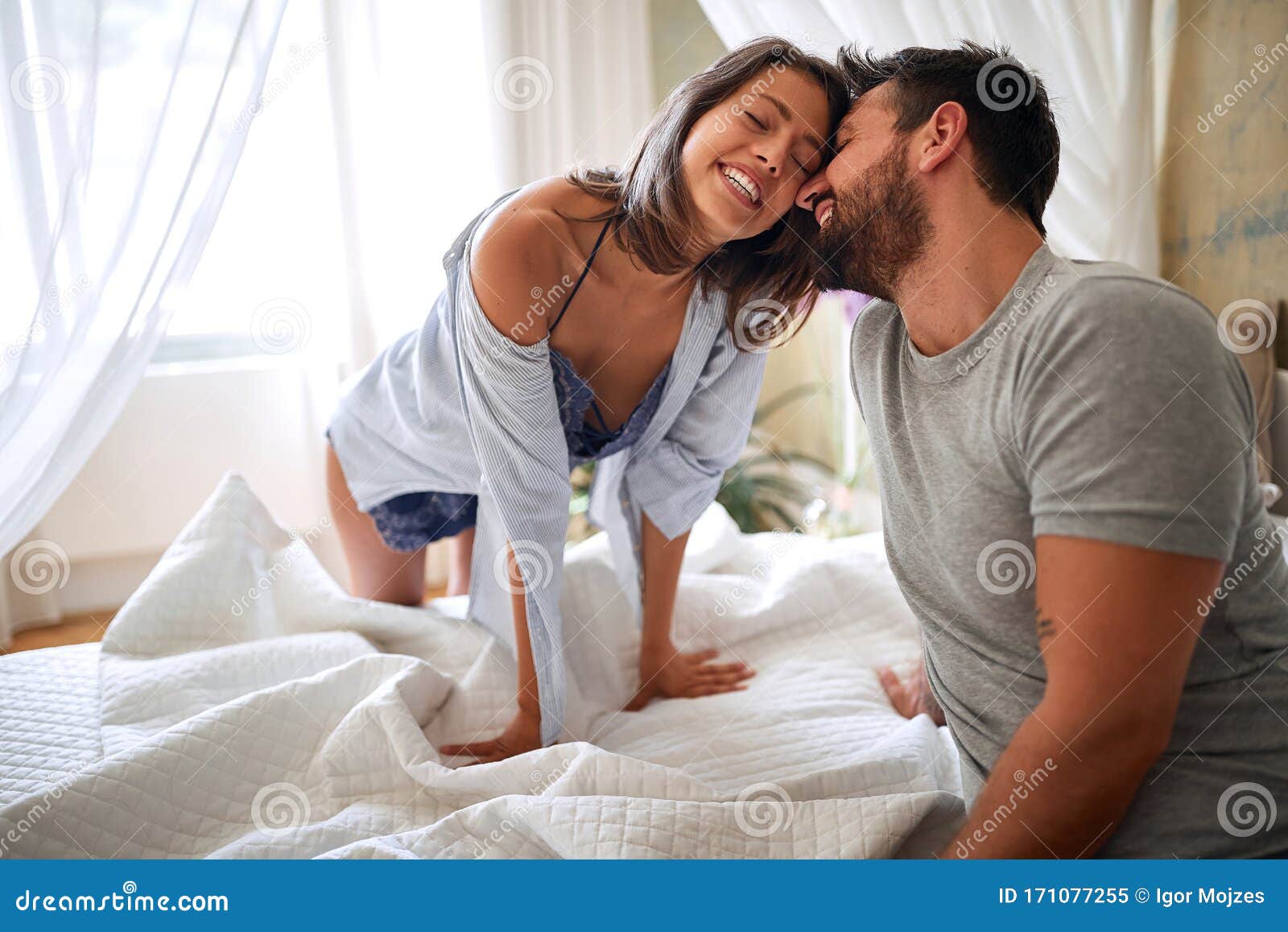 young sexy couple in underwear having a foreplay in bed in the morinig on valentines day. intimacy, passion, erotic concept