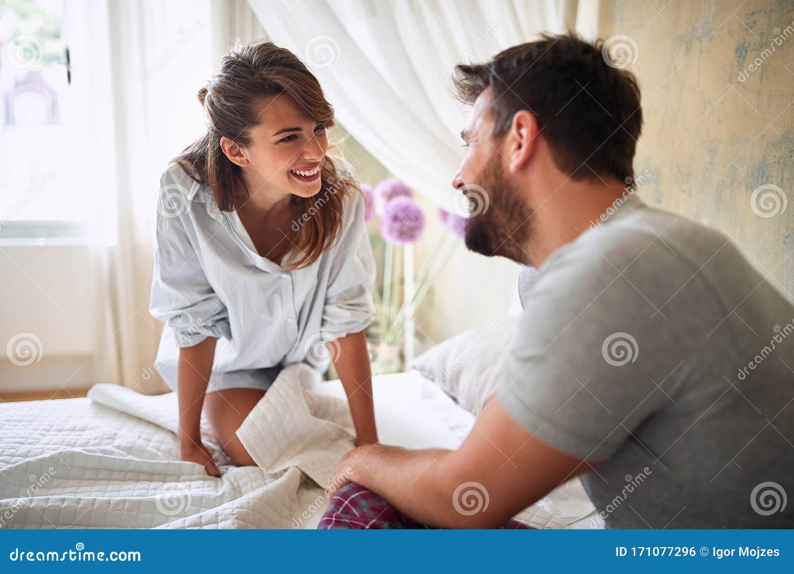 young sexy couple in underwear having a foreplay in bed in the morinig on valentines day. intimacy, passion, erotic concept