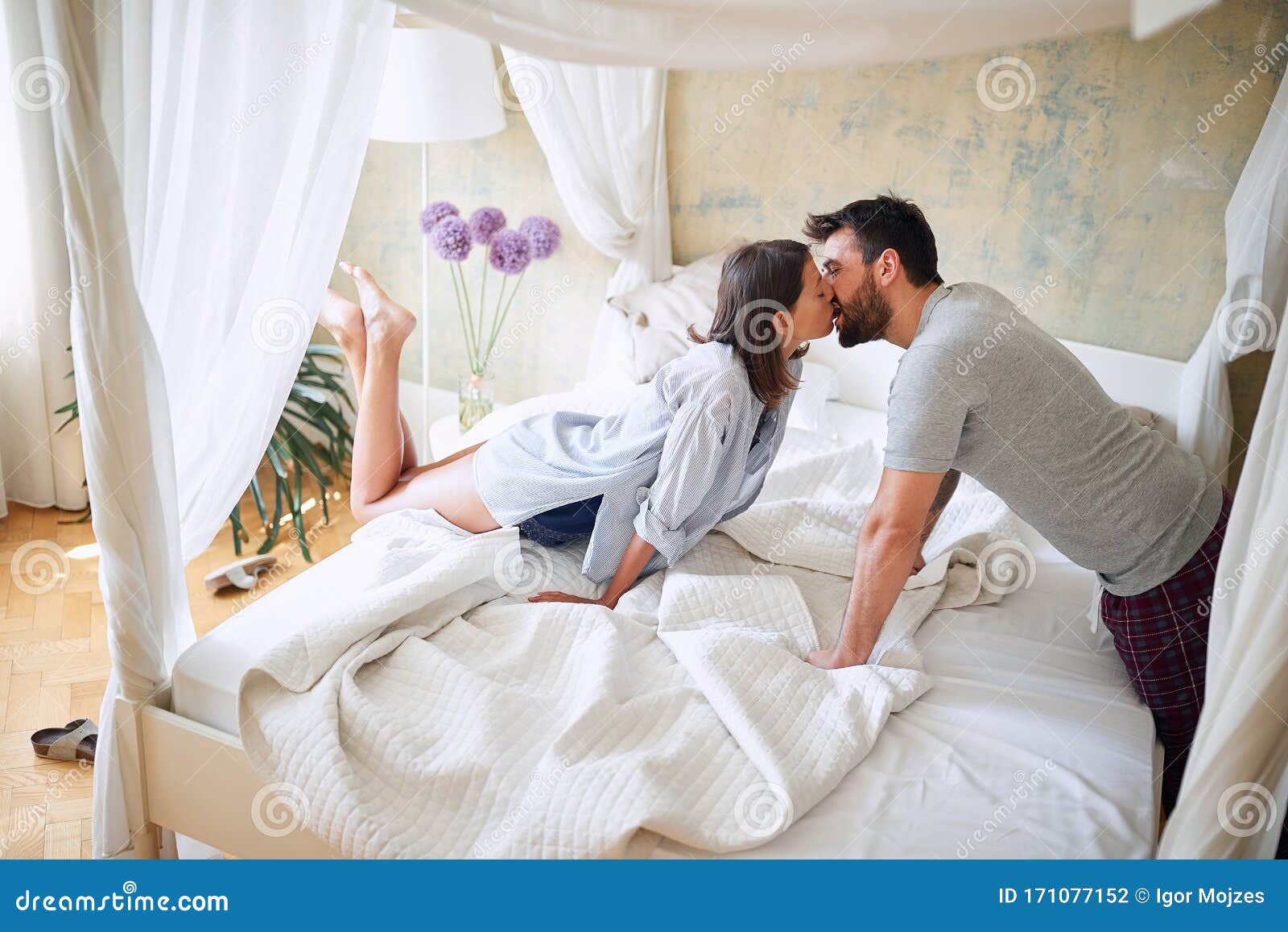 young sexy couple in underwear having a kiss in bed in the morinig on valentines day. intimacy, passion, erotic concept