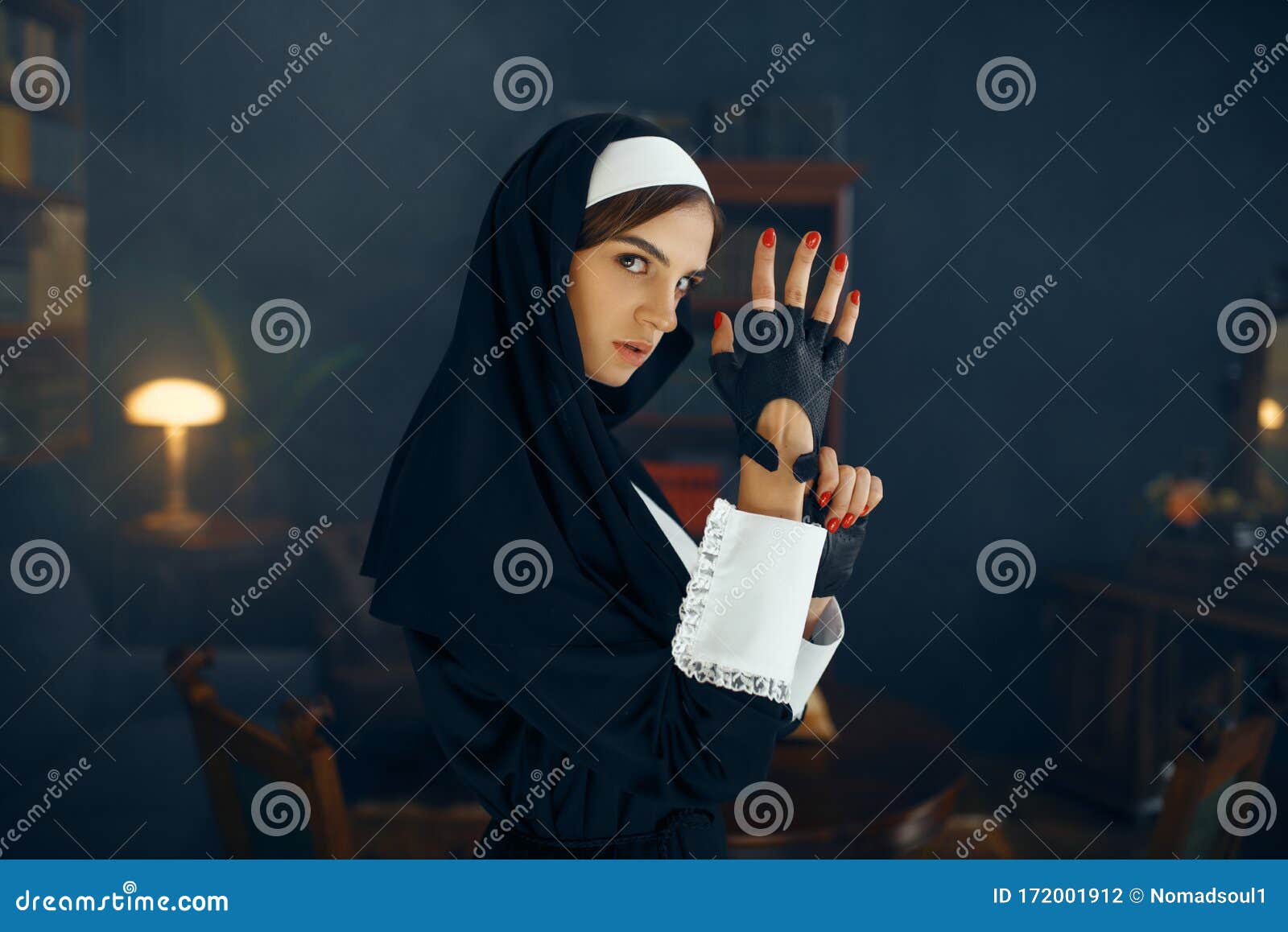 Young Nun in a Cassock Puts on a Glove Stock Photo Image of costume