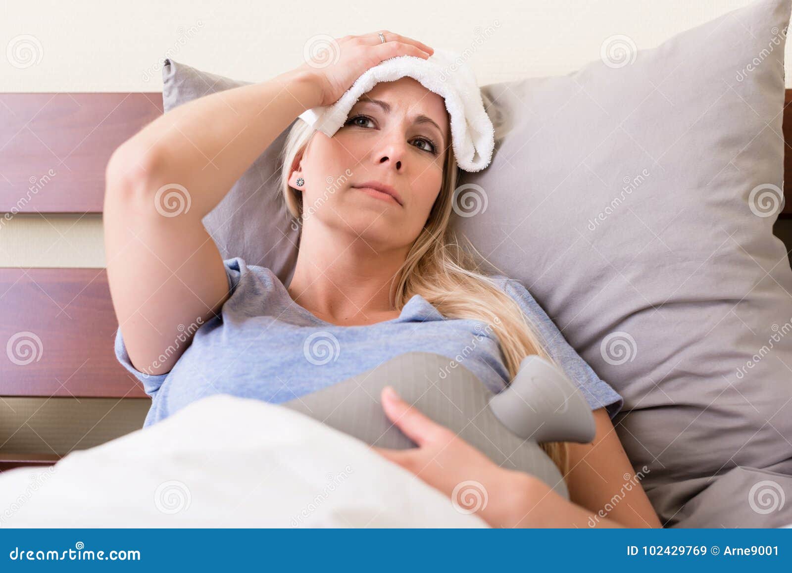 young sick woman with fever lying in bed