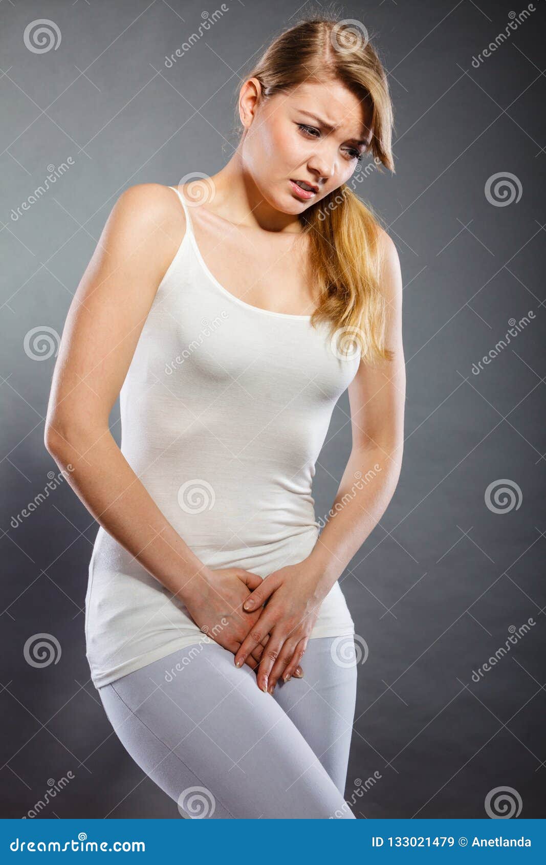 woman covering her crotch with her hands on white background Stock