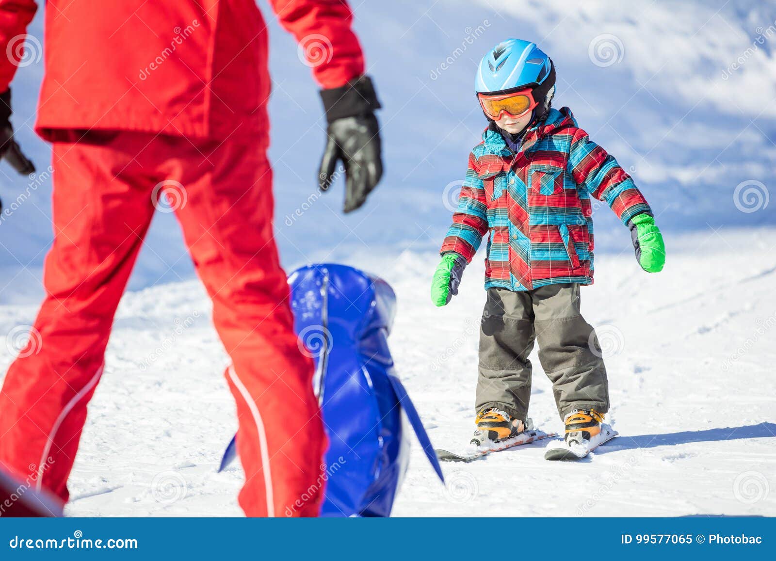 young skier sliding down towards towards toy penguin and ski ins