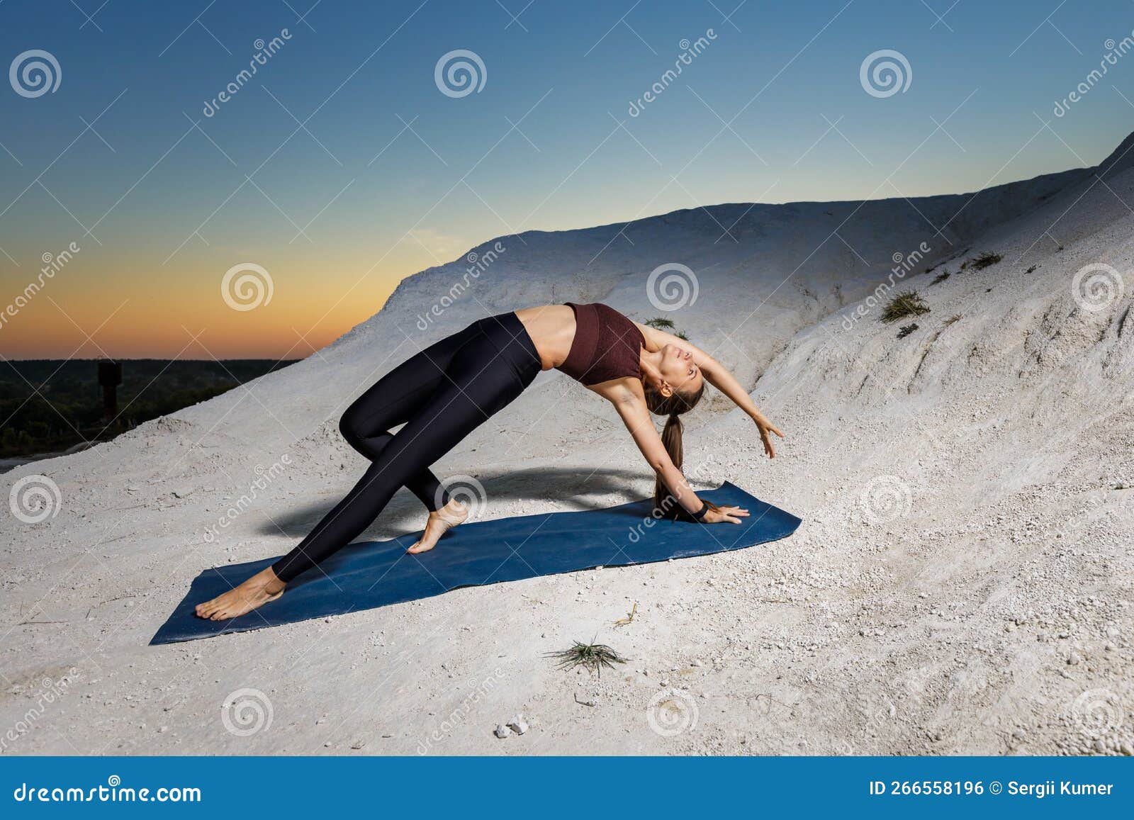 Young attractive woman practicing yoga, stretching in Wild Thing