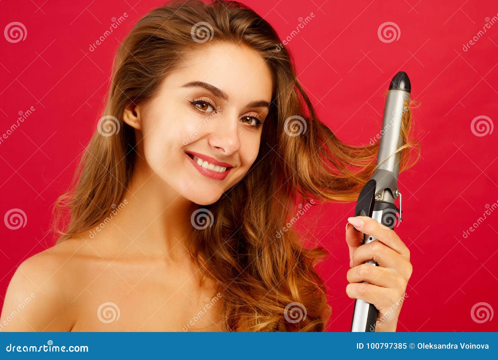 young smiley woman making curly hair by ploy over red background