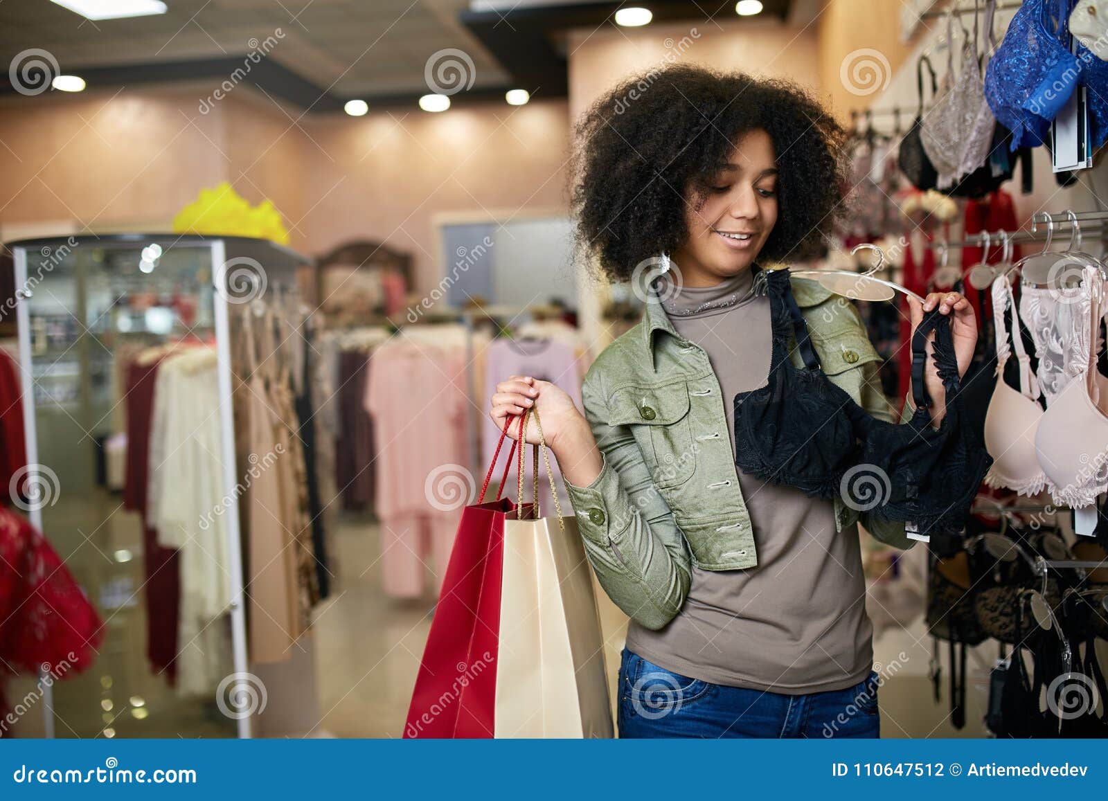 Young Smiling Attractive African American Woman Choosing Right Bra Size ...