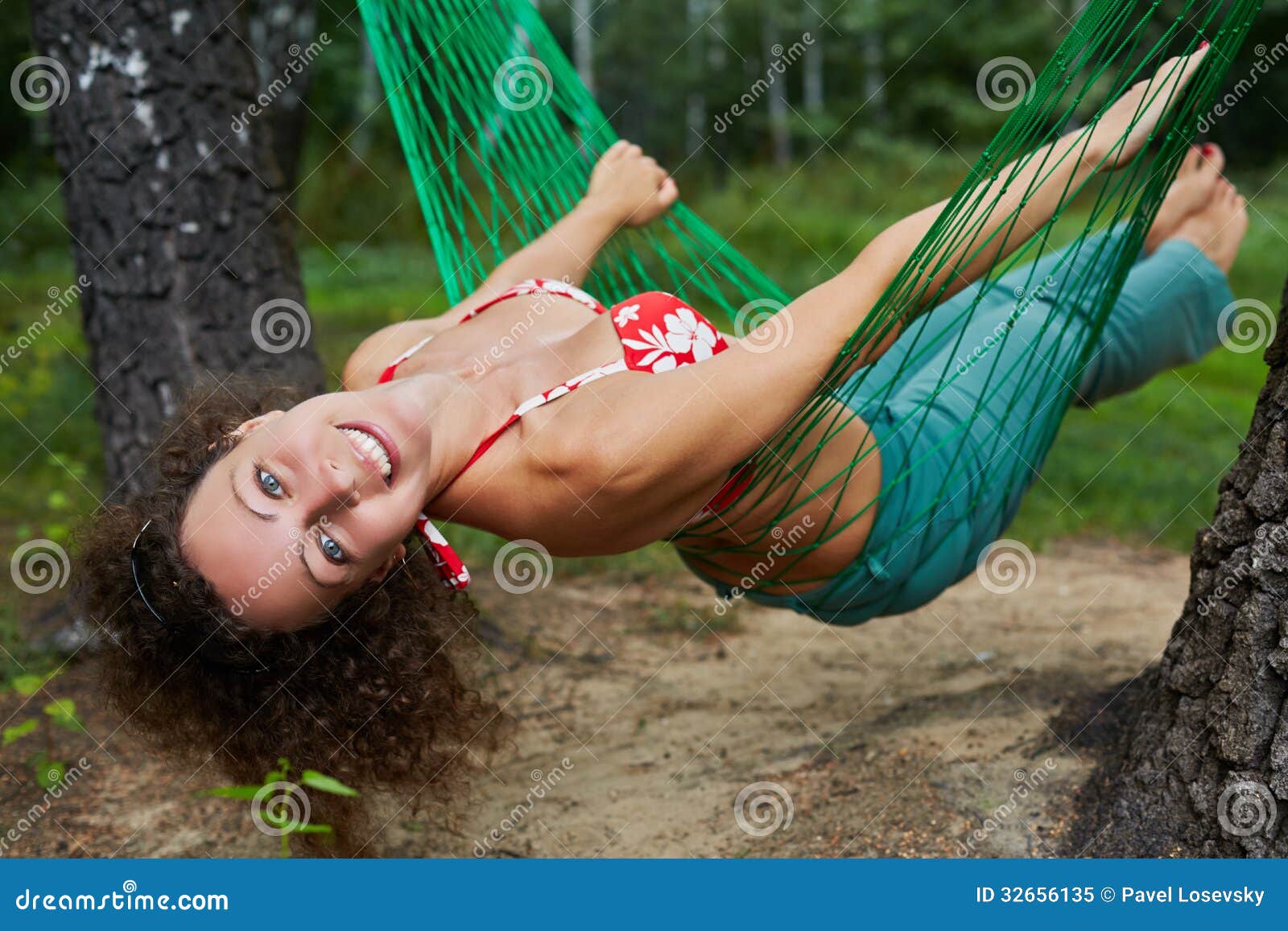 young smiling barefooted woman swing in hammock
