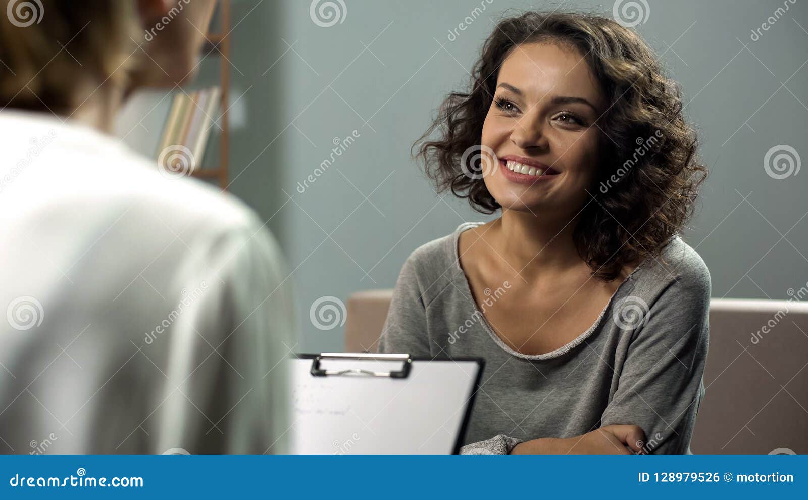 young smiling lady at rehab therapy session, help from psychologist, improvement