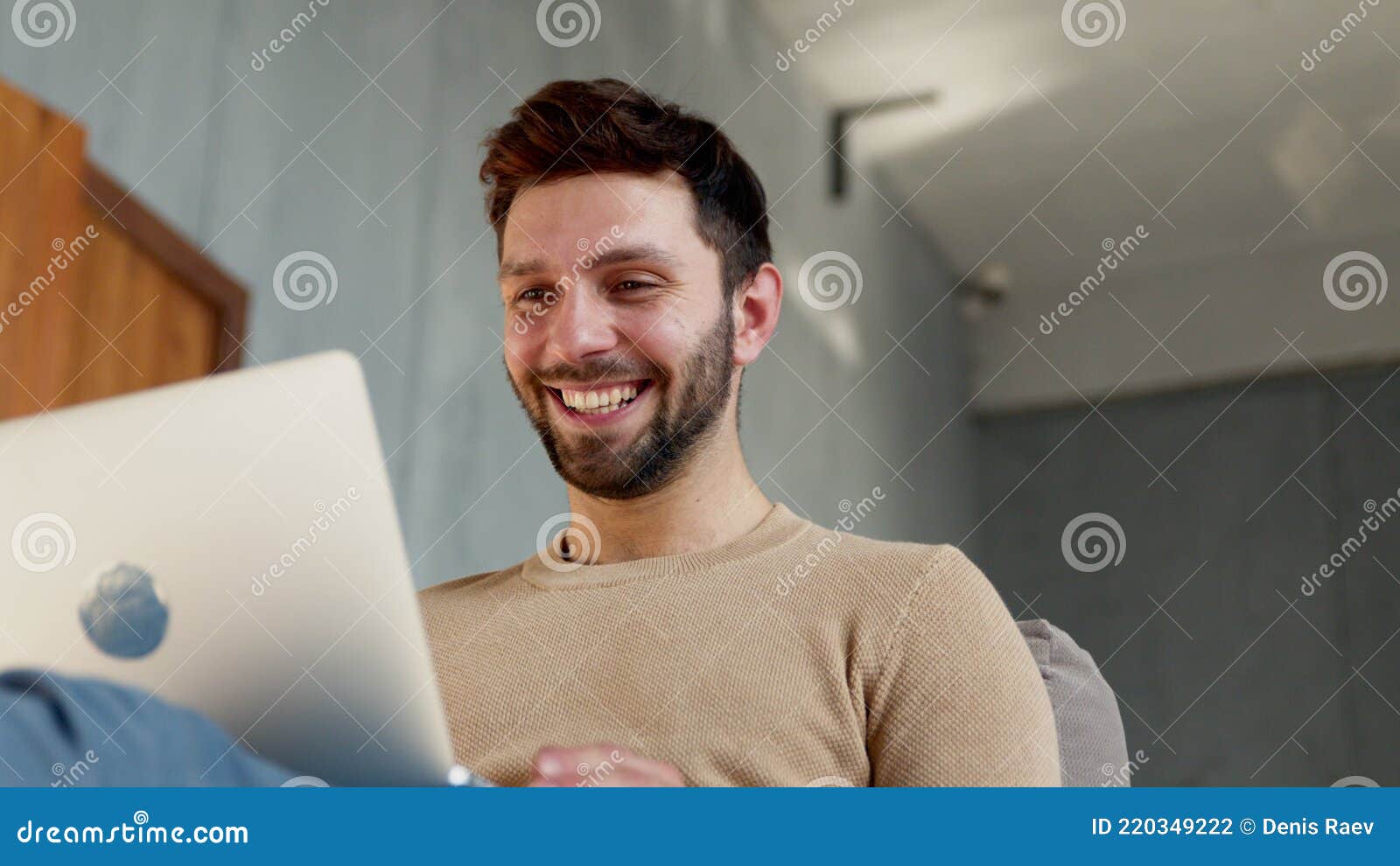 young smiling man communicating by videoconference