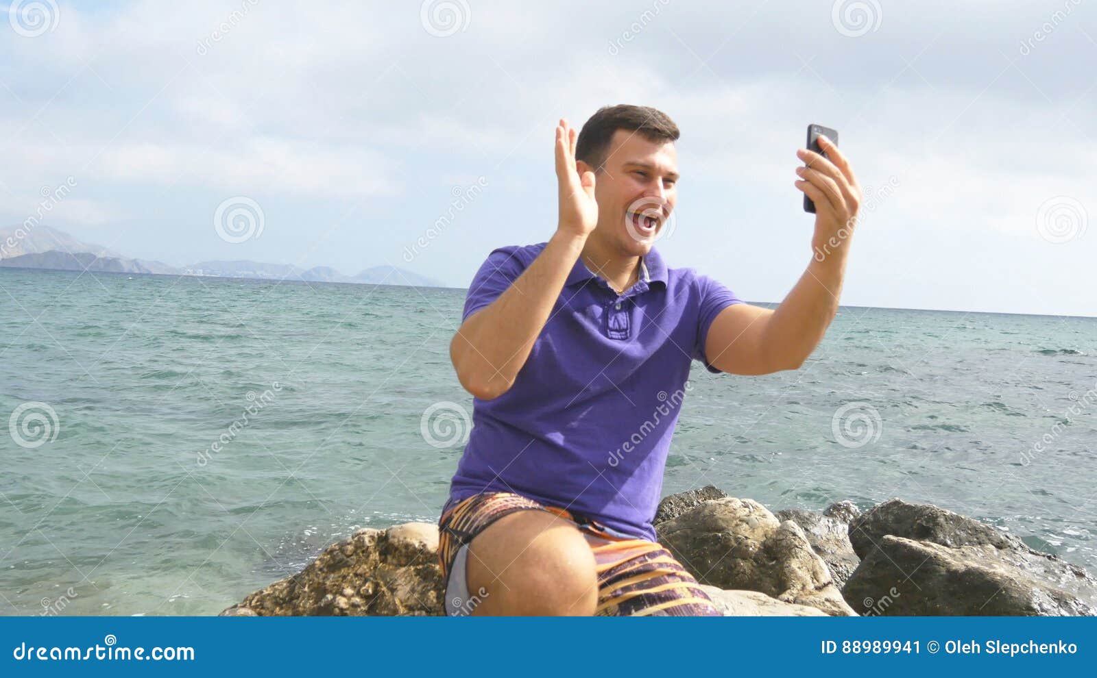 Young Smiling Man Having a Video Call on Smart Phone at the Sea Beach ...