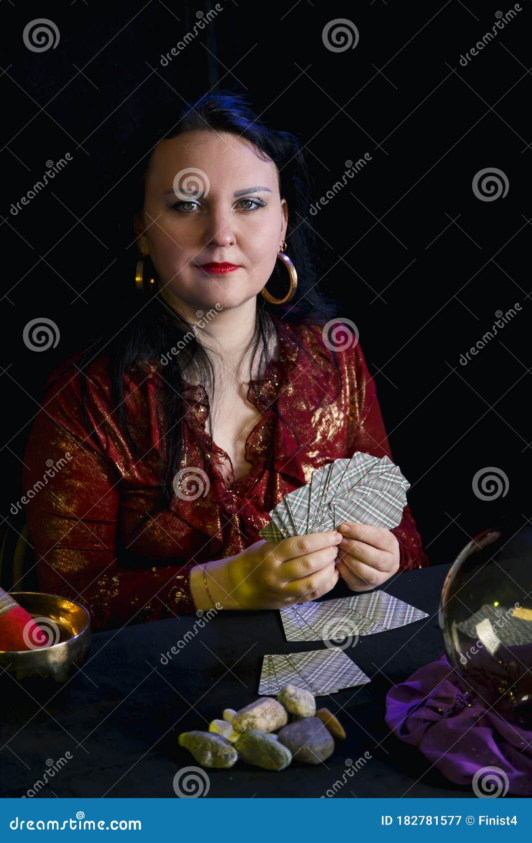 A Young Soothsayer in a Magic Salon with Cards in Her Hands on a Black ...