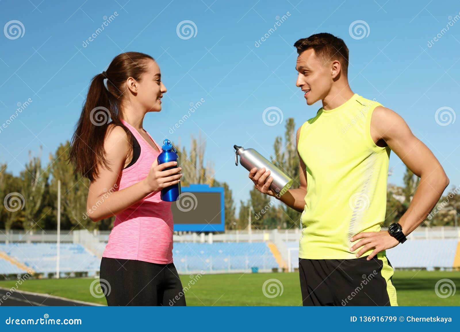 Young Sporty Couple Holding Bottles Of Water At Stadium Stock Image Image Of Drink Bottle