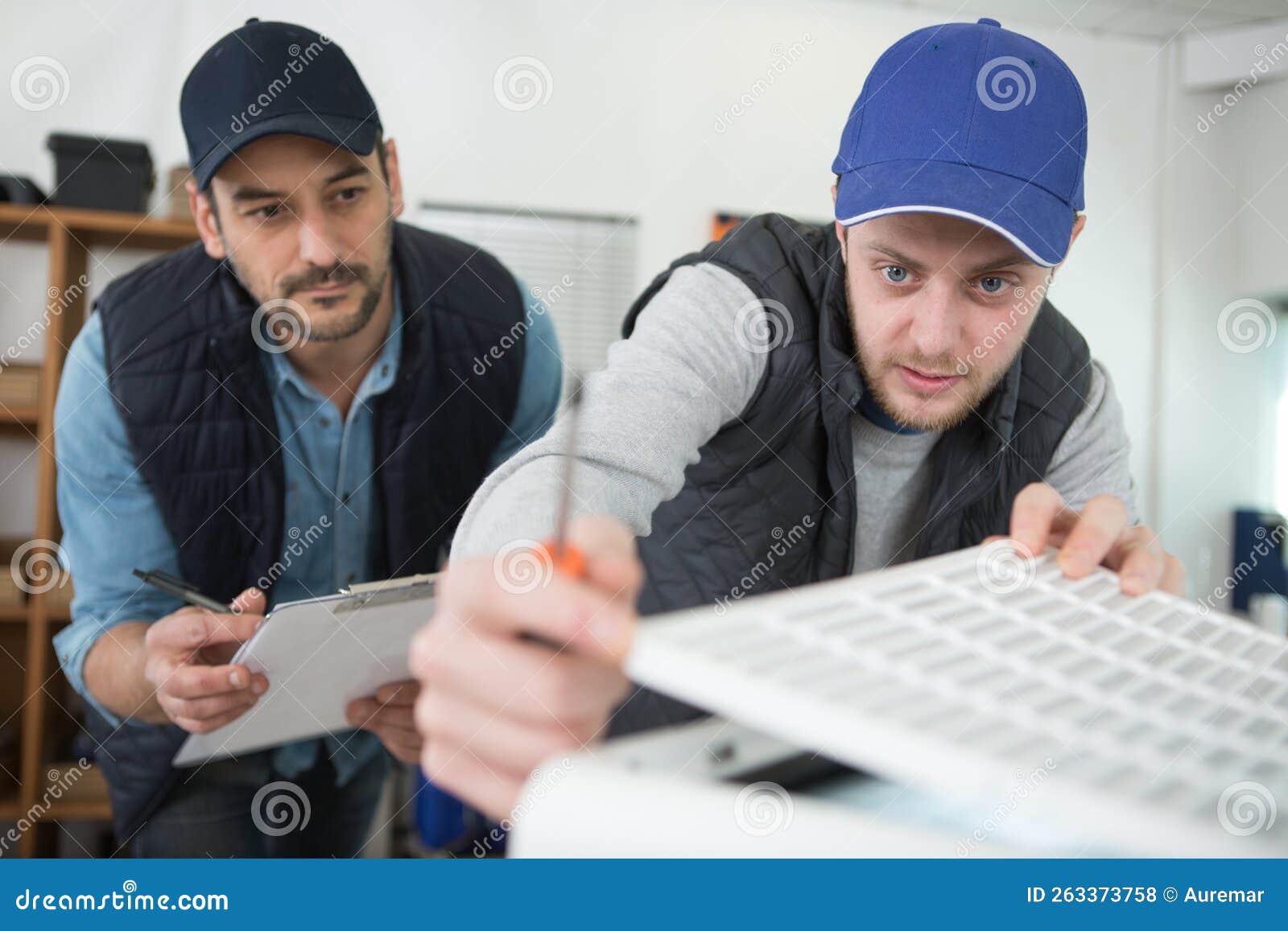Young Students Learning To Adjust Air Conditioning System Stock Photo