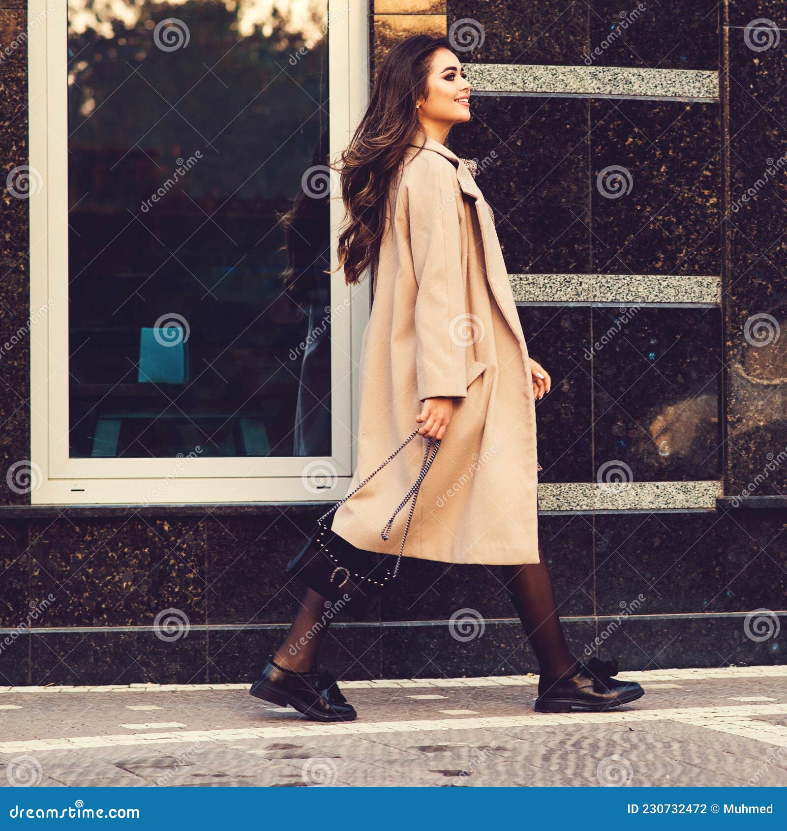  Woman walking in the street holding fashion handbag