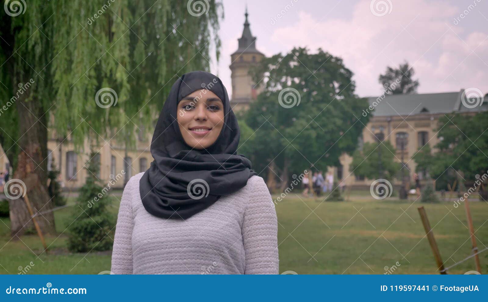 Young Sweet Muslim Girl In Hijab Is Standing And Smiling In Daytime In