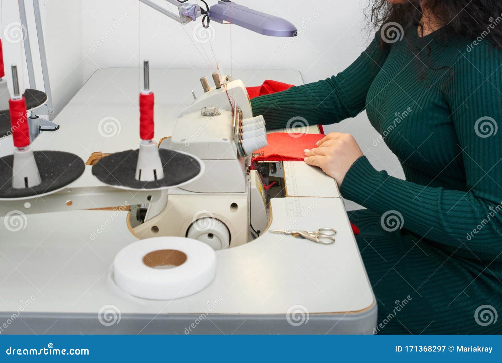 Young Tailor Using Professional Overlock Sewing Machine in