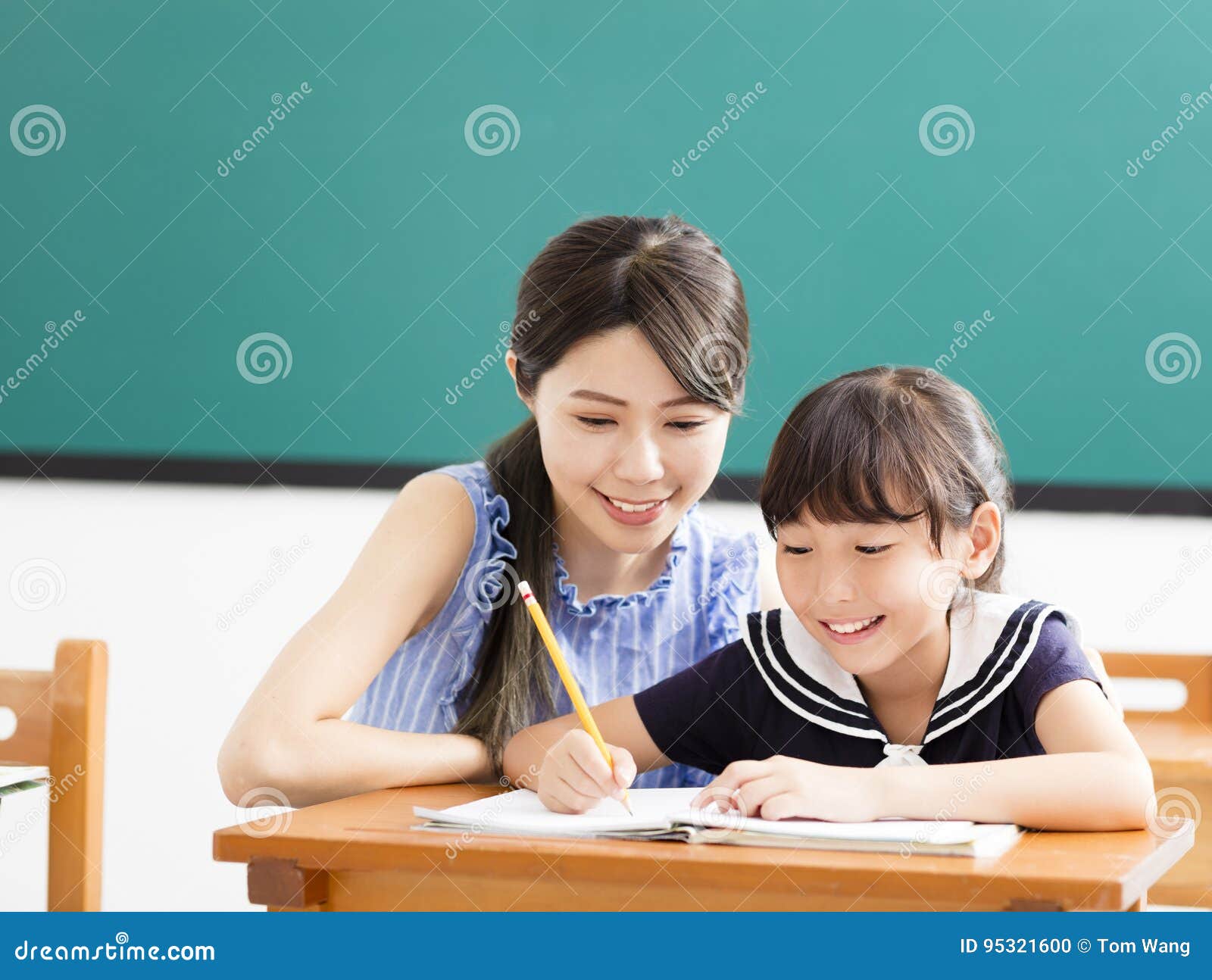 Young Teacher Helping Child with Writing Lesson Stock Photo Image of