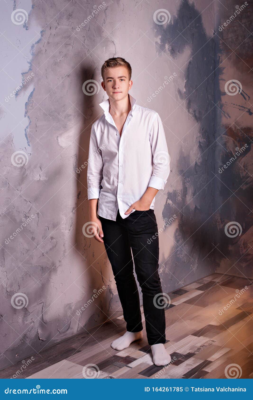 Young Guy a White Shirt and Black Jeans Stands Near the Wall and a Hand in His Pocket Stock Image - Image of necktie, portrait: 164261785