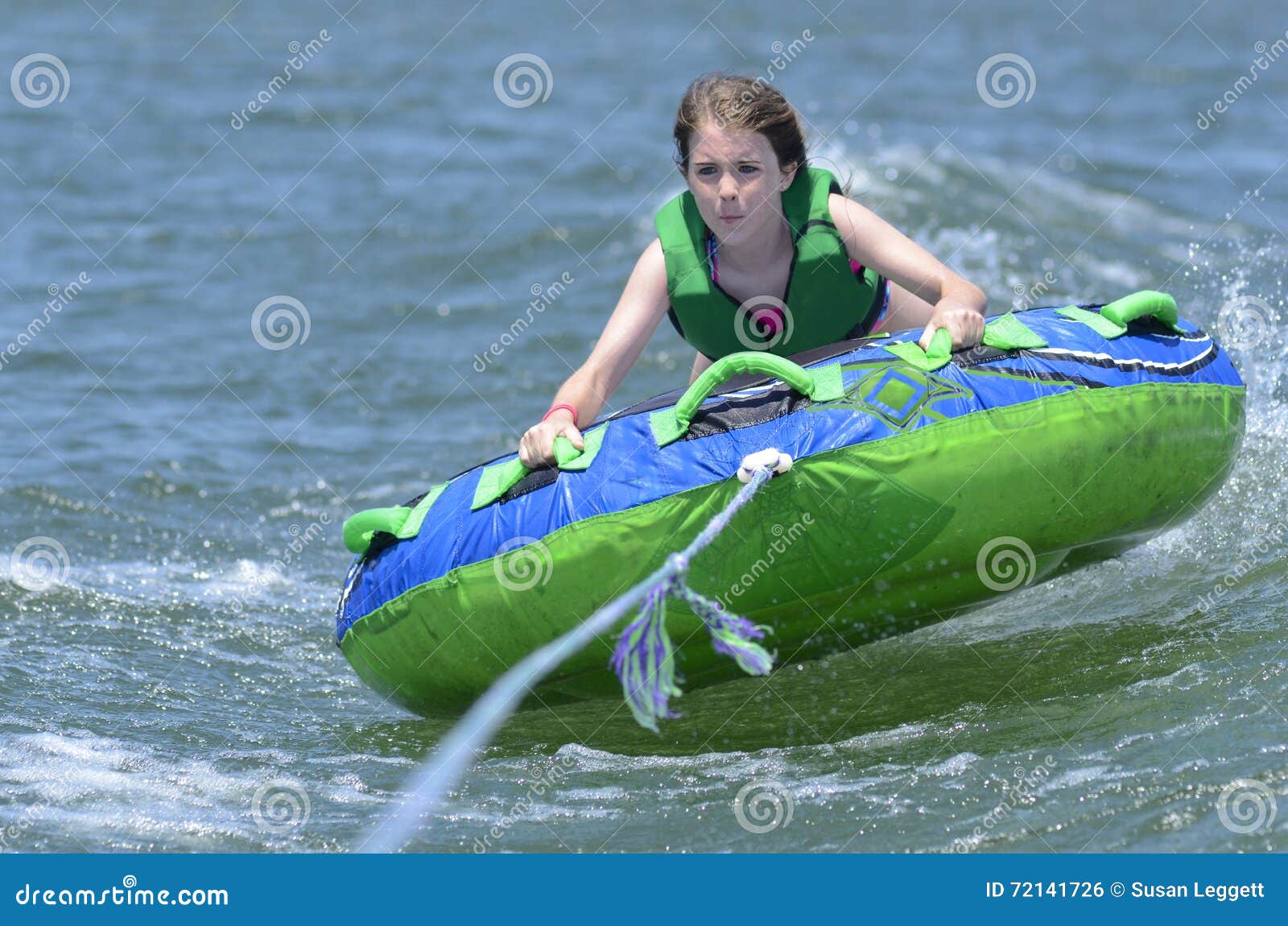 young teen tubing behind a boat