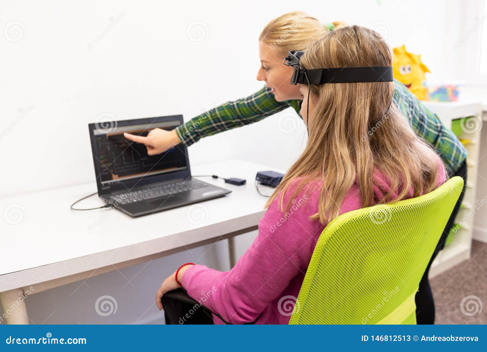 young teenage girl and child therapist during eeg neurofeedback session. electroencephalography concept.