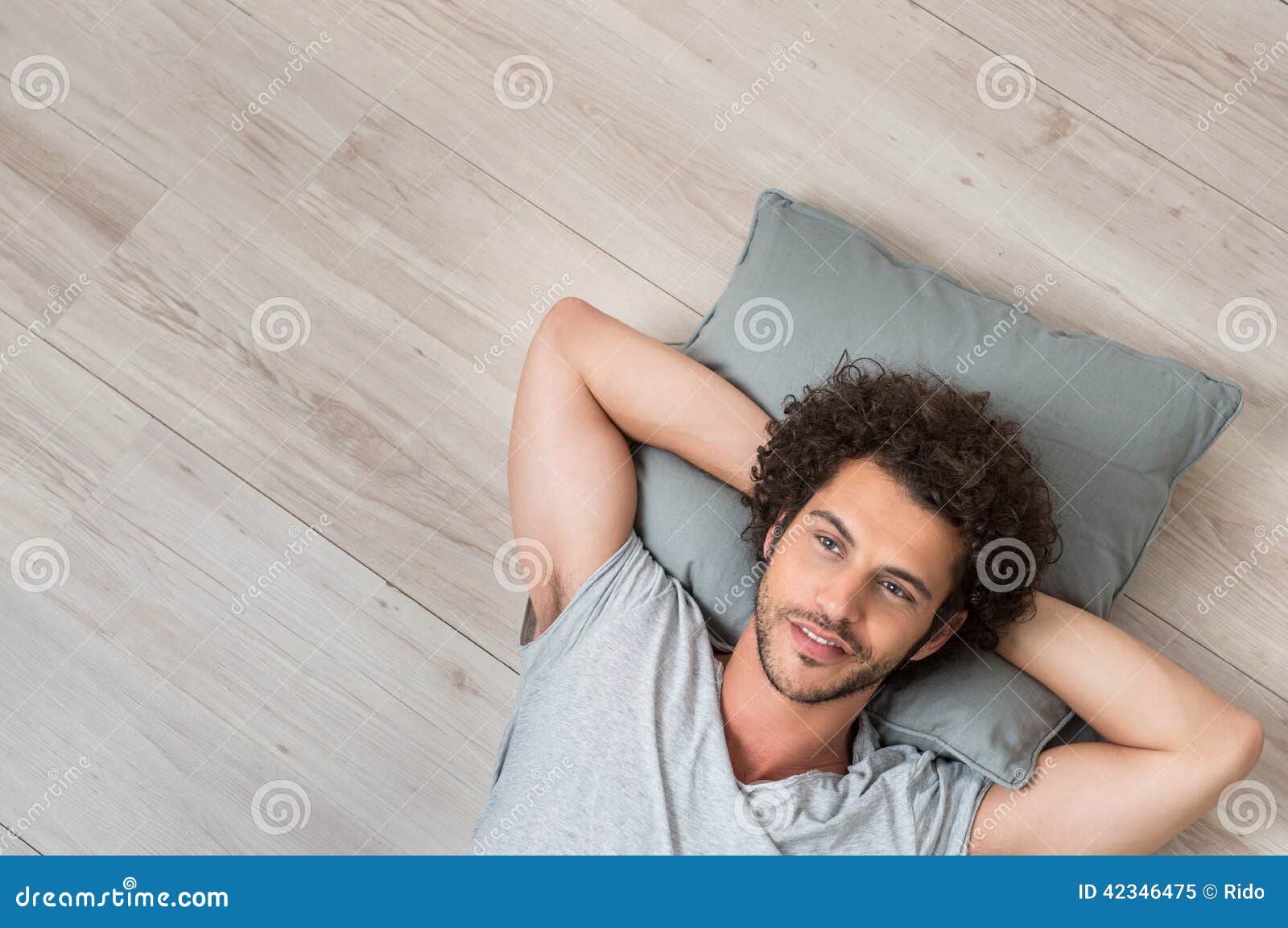 young thinking man lying on floor