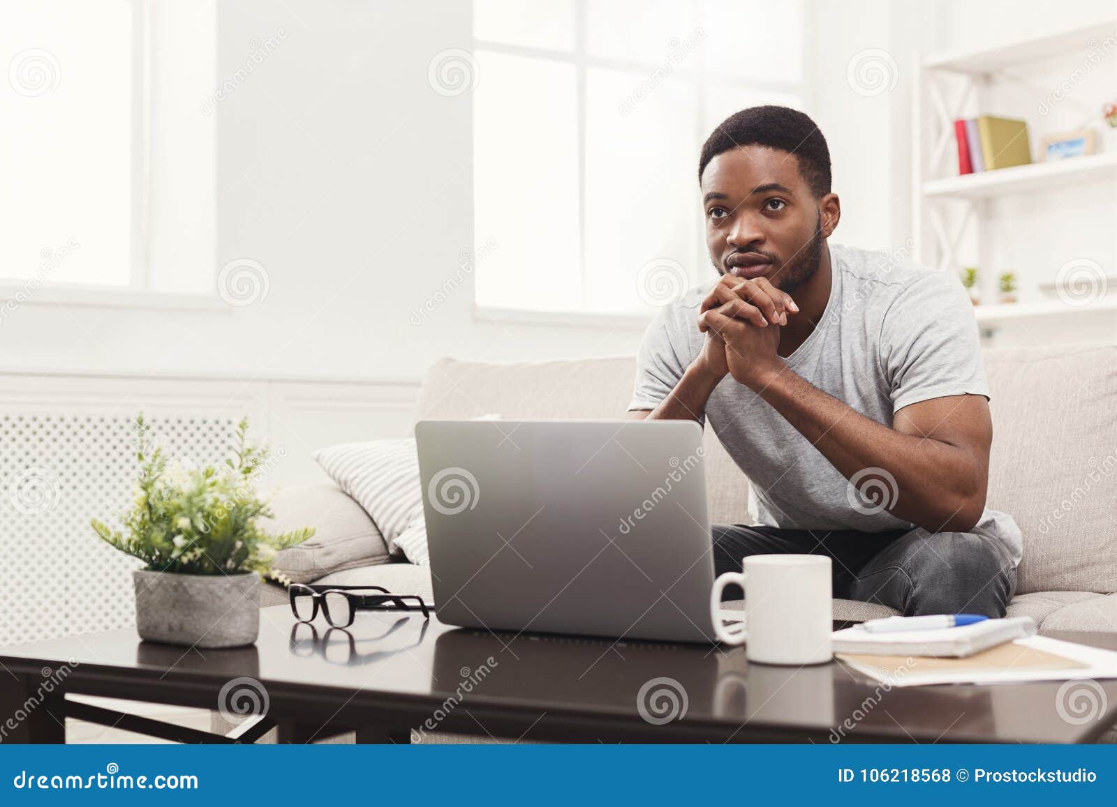 young thoughtful man at home messaging online on laptop