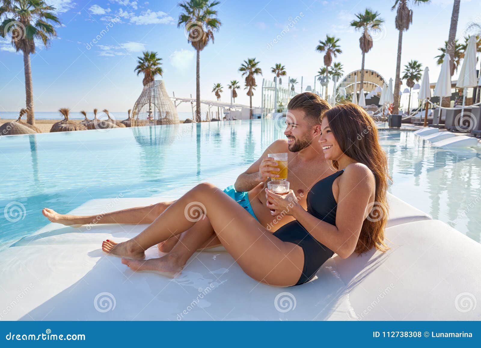 young couple on pool hammock at beach resort