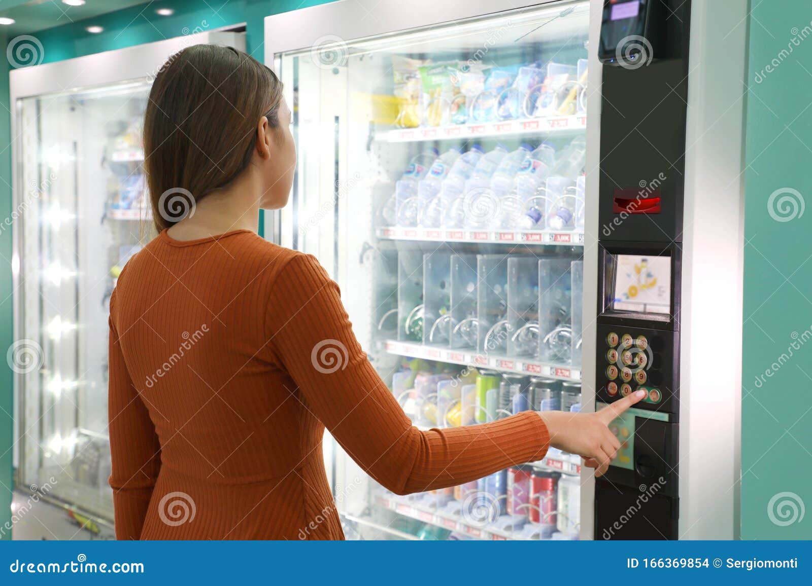 young traveler woman choosing a snack or drink at vending machine in airport. vending machine with girl