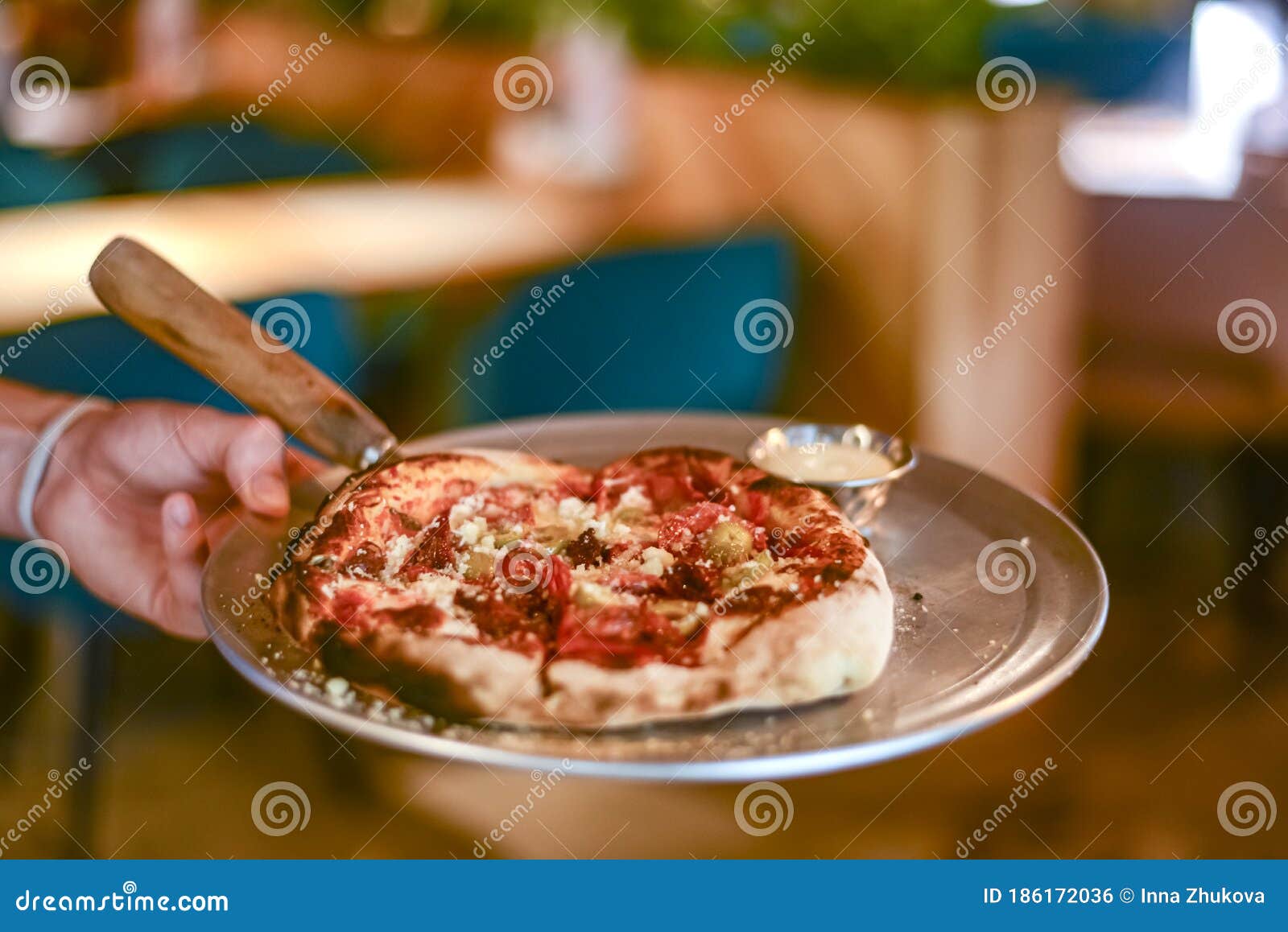 Young Waiter Holding Plate with Tasty Pizza, Close Up View. Waiter at ...