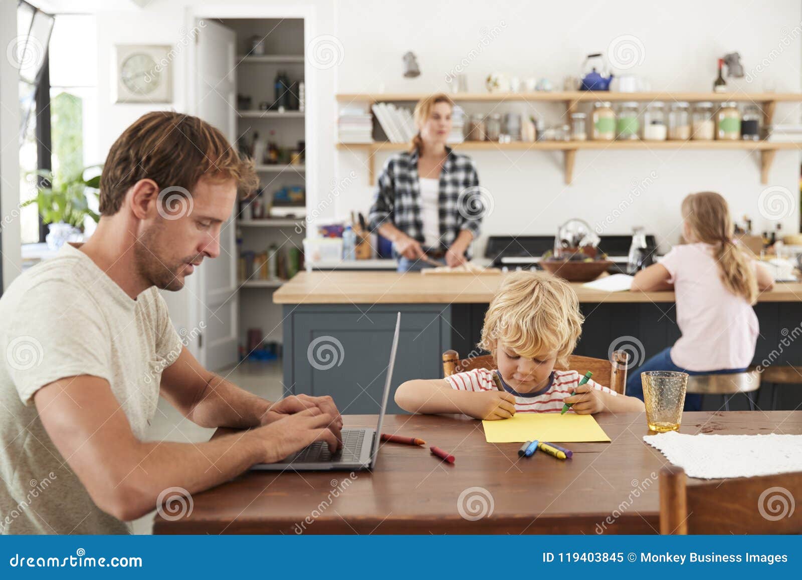young white family of four busy in their kitchen, close up