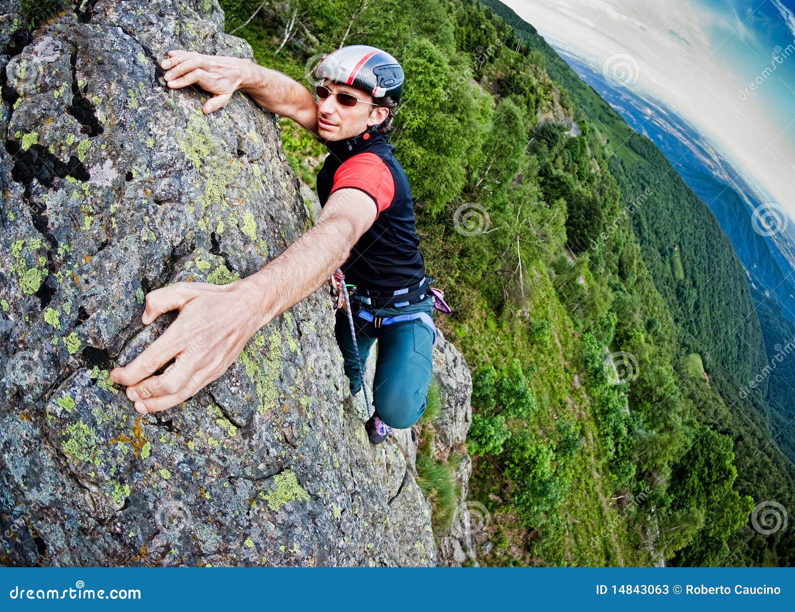 young white man climbing a steep wall