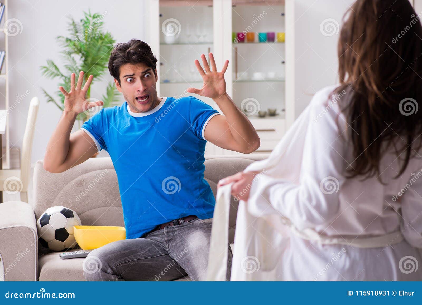 Young Wife is Trying To Seduce Husband from Watching Football an Stock Image image