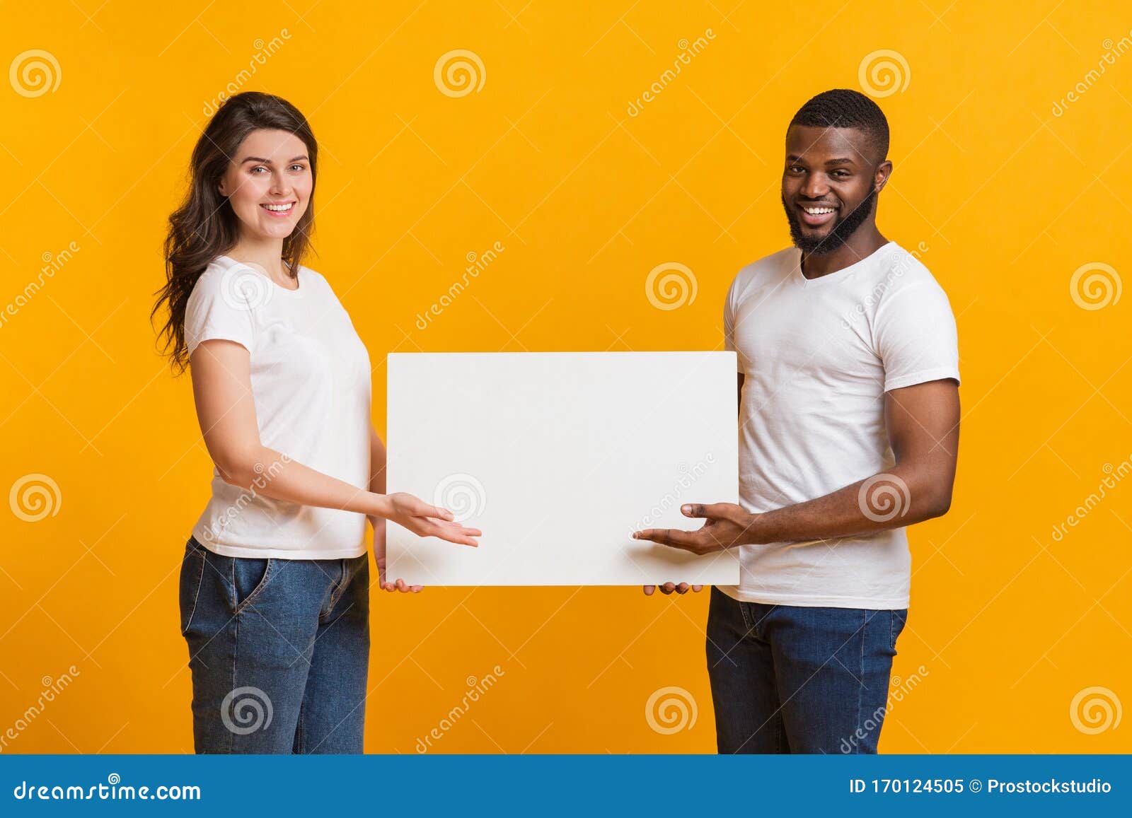 young woman and afro man holding and pointing at blank placard