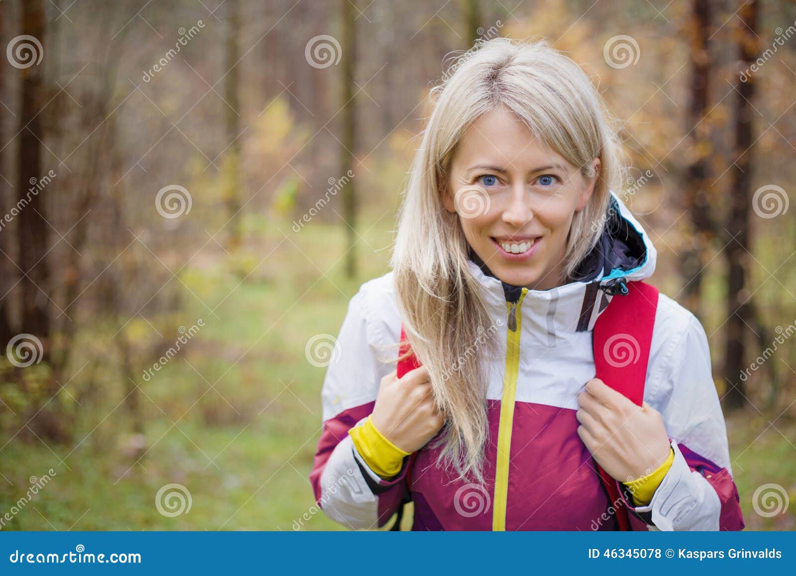 young woman with backpack hiking in woods
