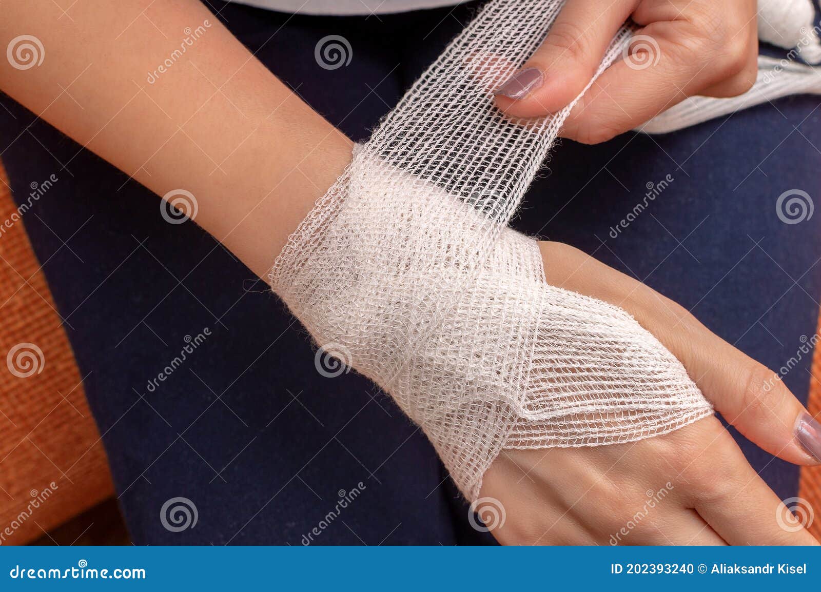 Doctor wrapping bandage around young woman's chest on white background,  closeup Stock Photo
