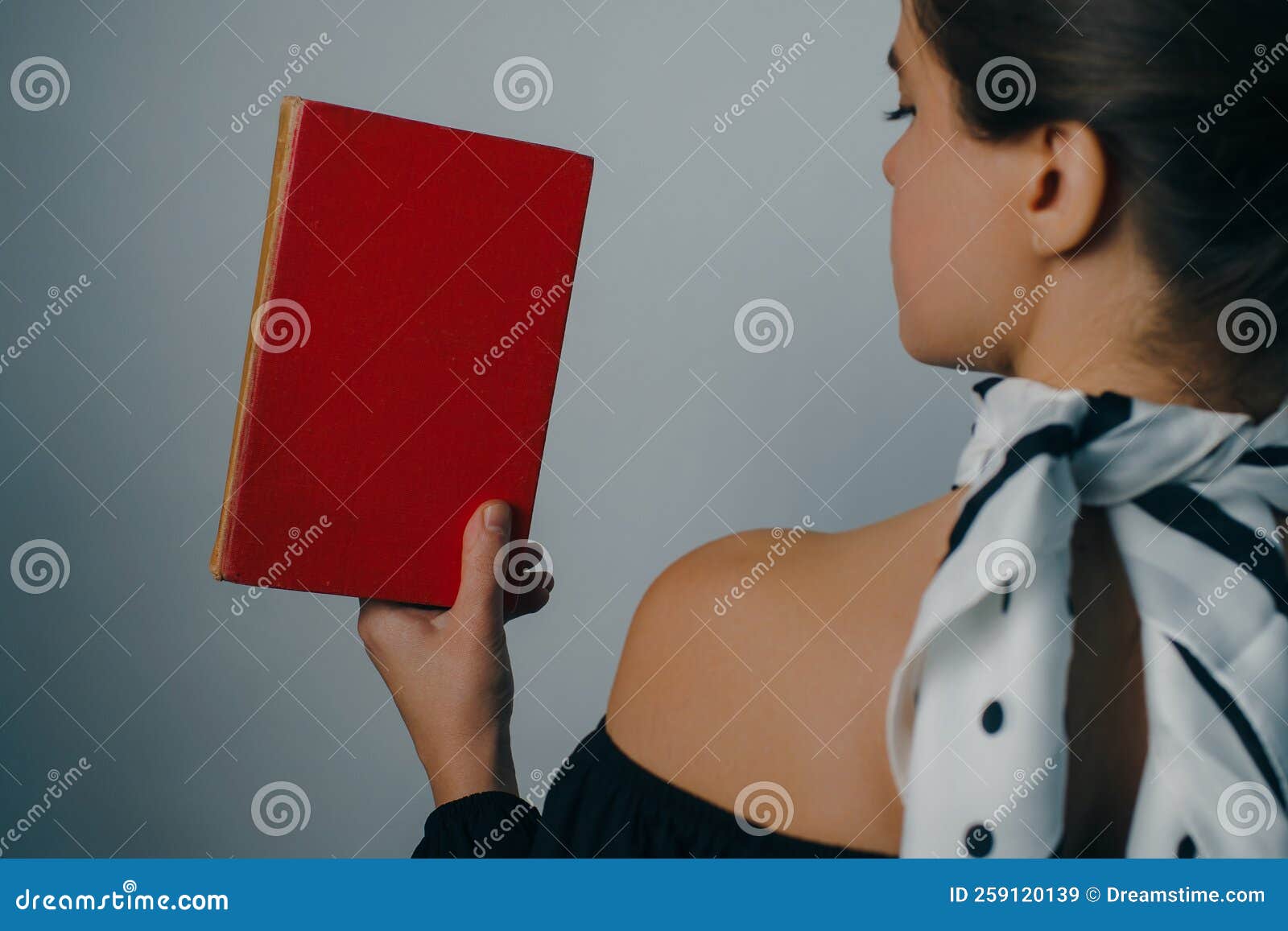 young woman with bare shoulders holding vintage books