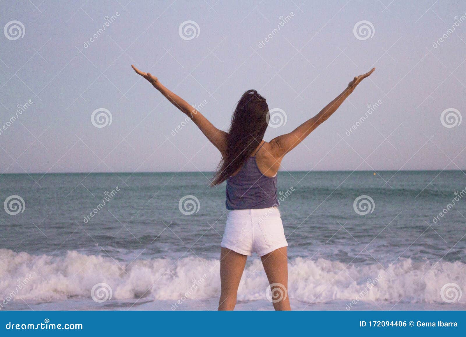 young woman on the beach in very positive and happy attitude