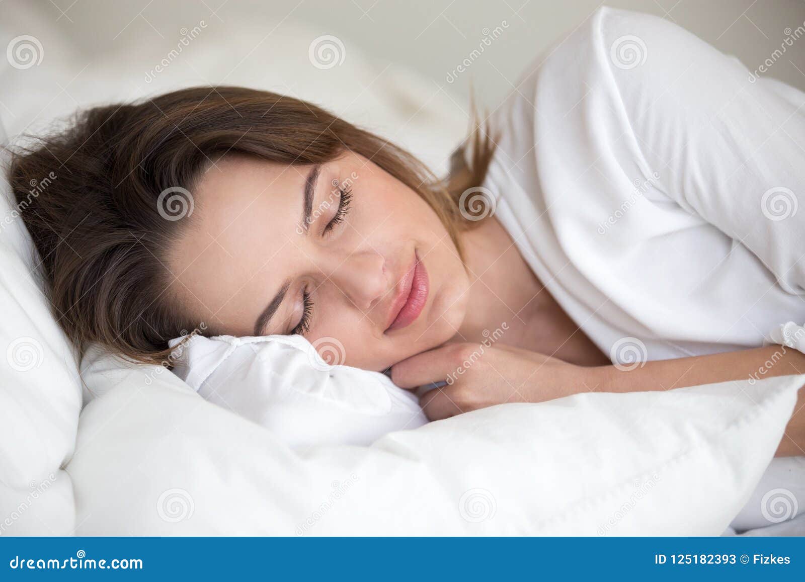 young woman sleeping well lying asleep in comfortable cozy bed