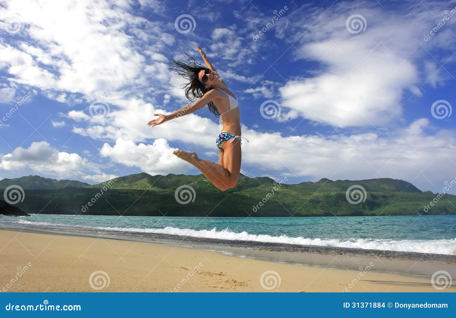 young woman in bikini jumping at rincon beach, samana peninsula
