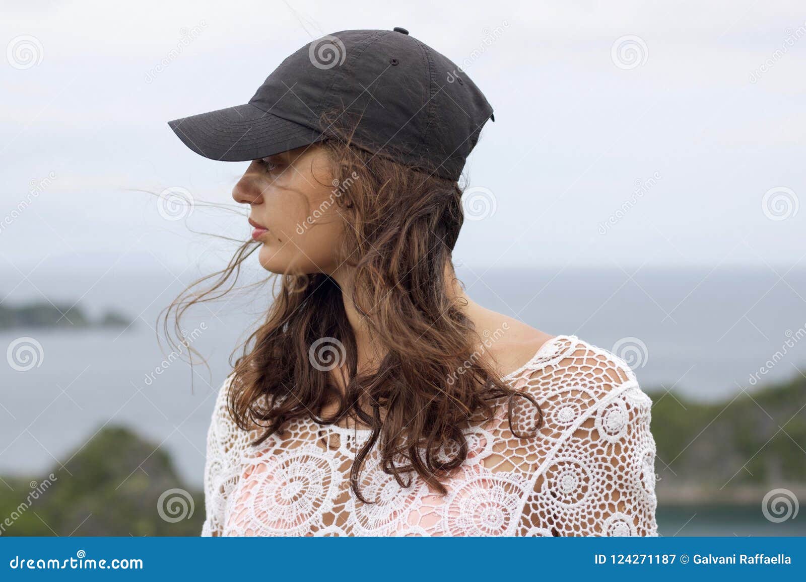 young woman with black hat and white lace shirt