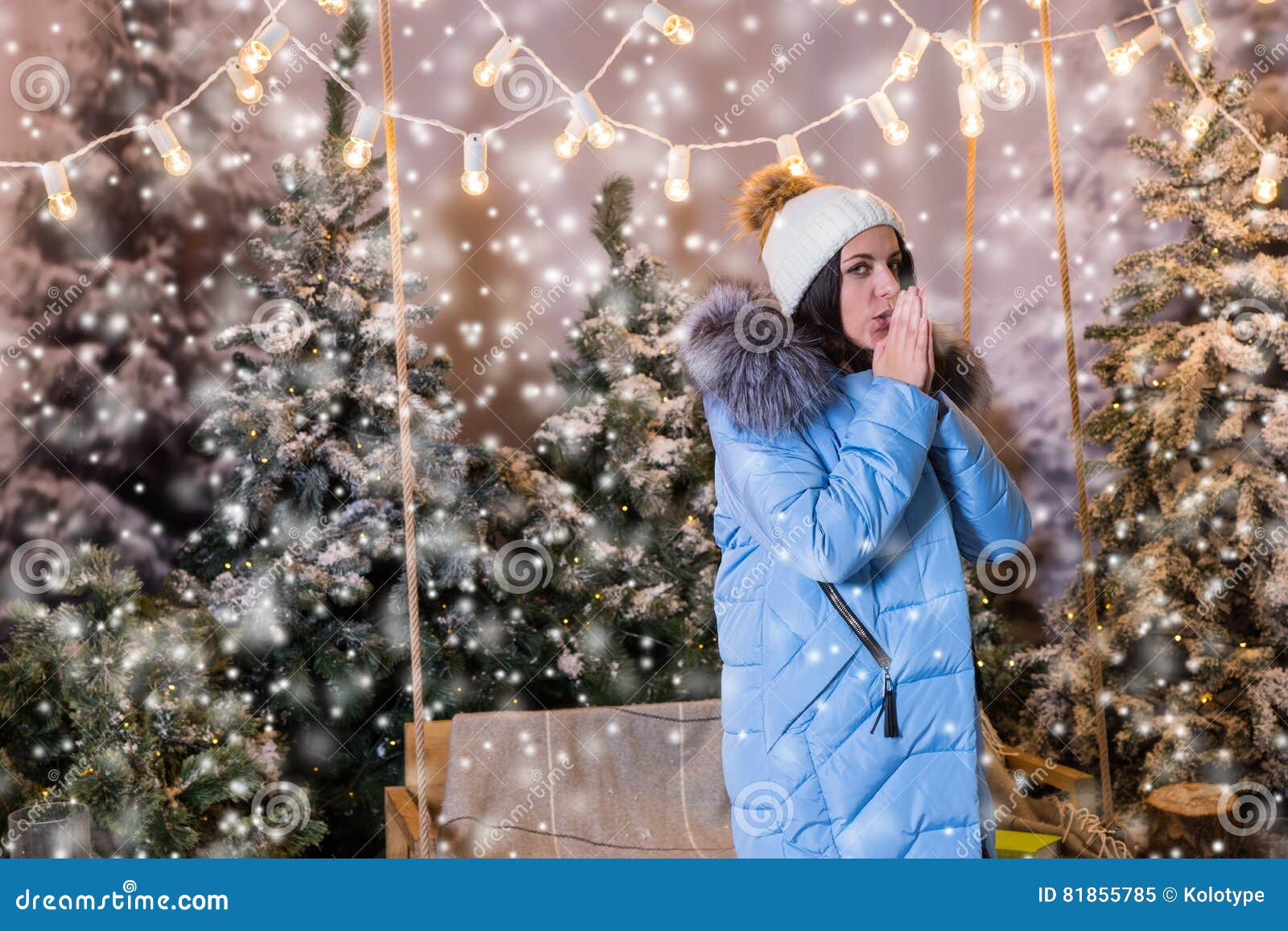 Young Woman in Blue Down Jacket Warming Hands and Standing Near Stock ...