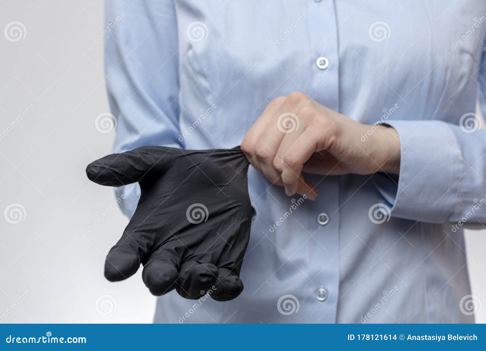 Young Woman in Blue Office Blouse Puts on Black Latex Gloves before ...