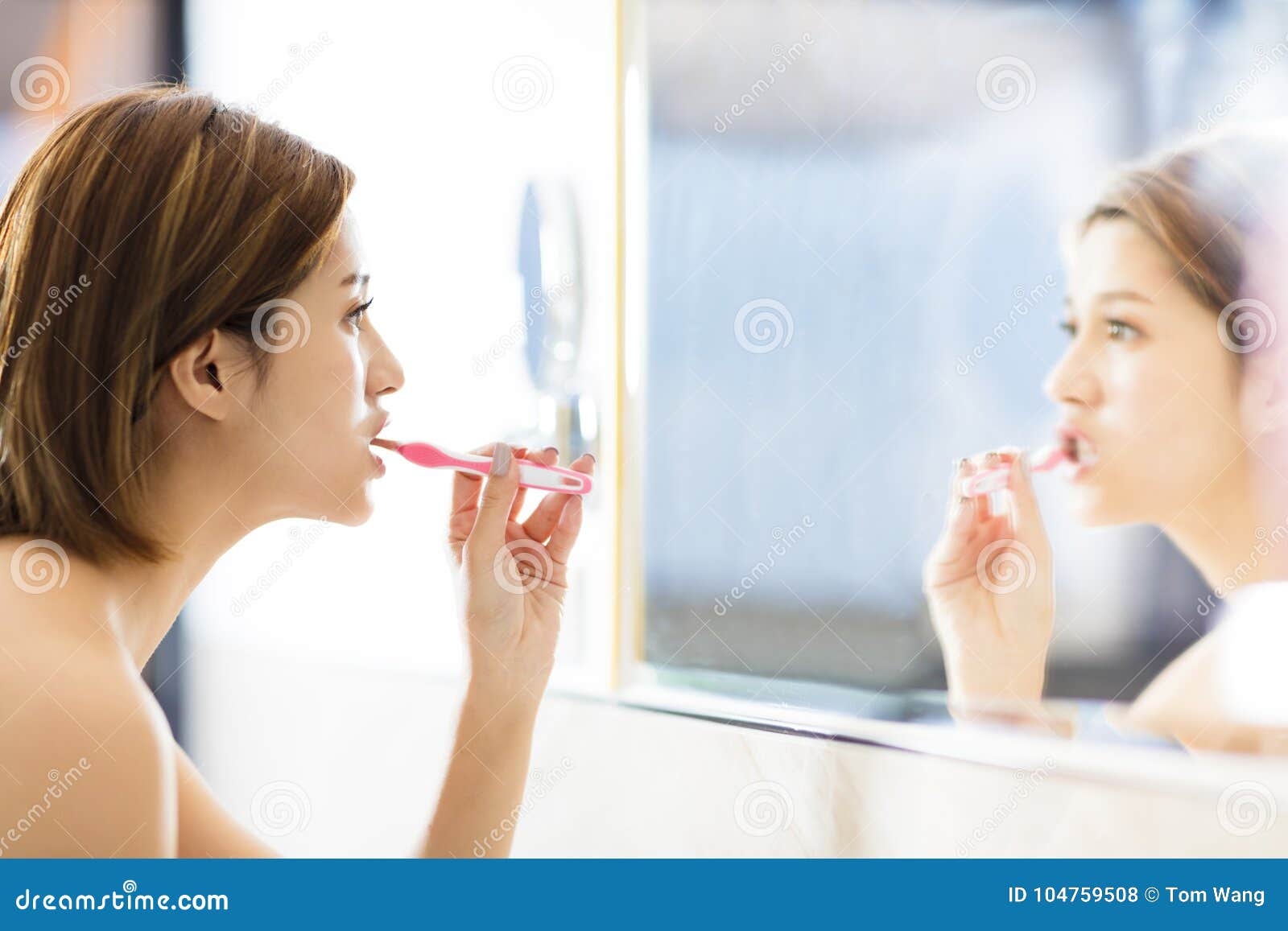 Woman Brushing Teeth and Looking in the Mirror Stock Photo Image of
