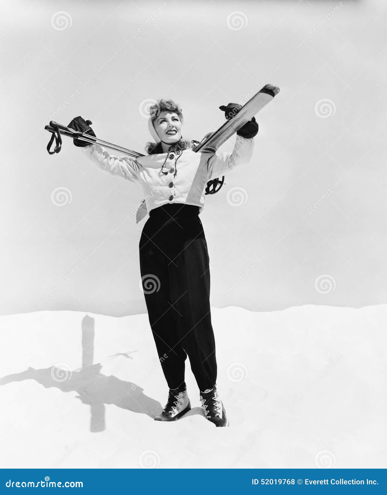 young woman carrying ski and ski pole on her shoulders