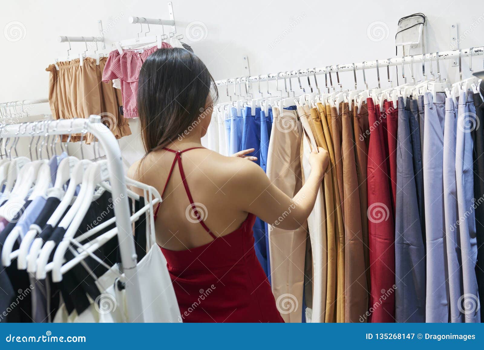 Young woman choosing pants stock image. Image of helping - 135268147