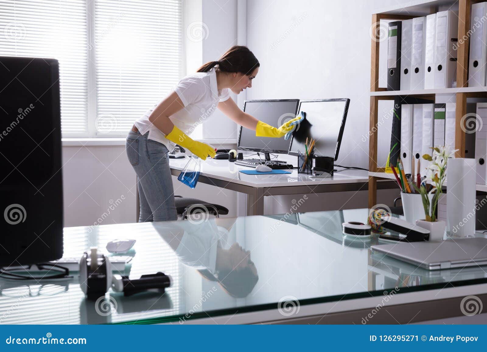 woman cleaning computer in office